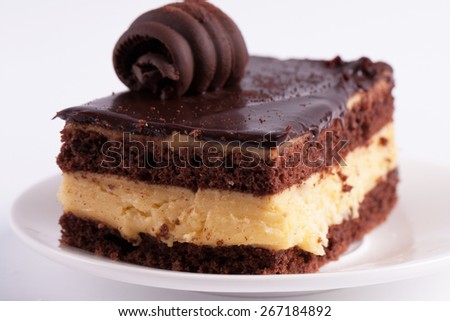 Piece of chocolate cake on white isolated background. Chocolate cake slice with curl