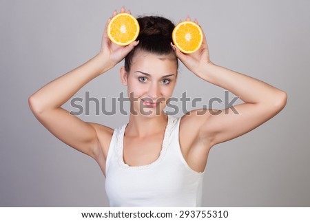 Beautiful close-up portrait of young woman with oranges. Healthy food concept. Skin care and beauty. Vitamins and minerals.