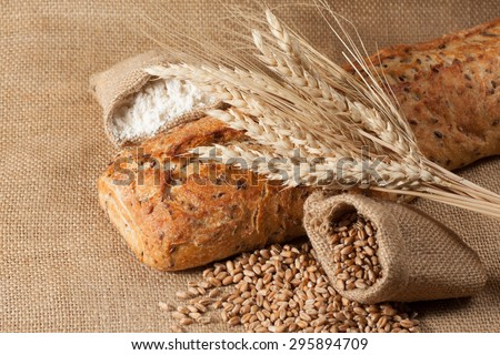 retro bread in rustic style background.Fresh traditional bread on wooden ground with flour in a sack. wheat germs and flour.