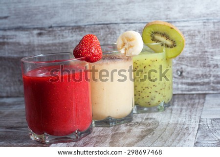 Fresh Made Chocolate Banana Smoothie, kiwi juice and strawberry juice on a wooden table. Selective focus. Milkshake. Protein diet. Healthy food concept.