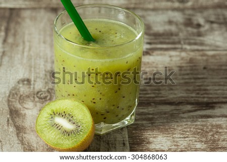 green kiwi juice, smoothie on wooden background. healthy drink in a glass. diet. summer drink and refreshment.
