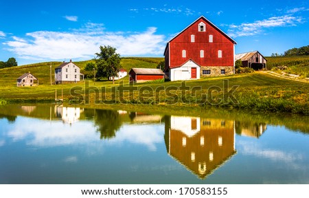 Reflection of house and barn in a small pond, in rural York County, Pennsylvania.