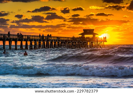 Sunset over the fishing pier and Gulf of Mexico in Naples, Florida.