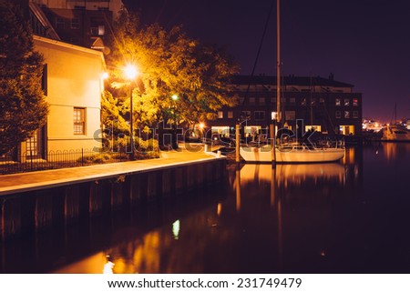 Boat and waterfront promenade in Fells Point at night, Baltimore, Maryland.