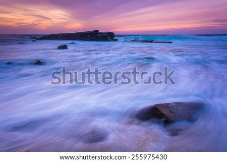 Waves and rocks in the Pacific Ocean at sunset, seen at Shell Beach, in La Jolla, California.