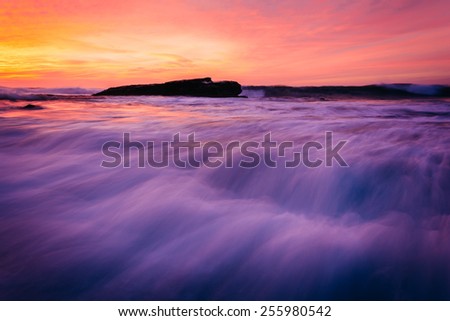 Waves and rocks in the Pacific Ocean at sunset, seen at Shell Beach, in La Jolla, California.