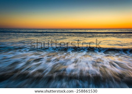 Sunset over waves in the Pacific Ocean, in Santa Monica, California.