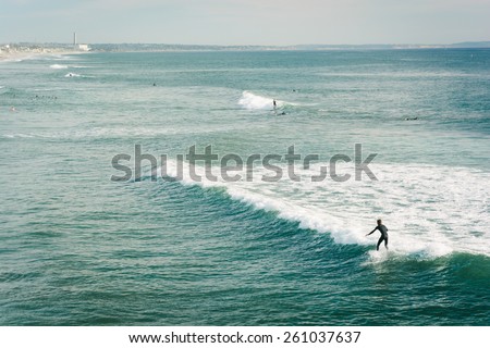 Surfer riding a wave in the Pacific Ocean, in Oceanside, California.