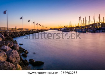 Breakwater and boats at the harbor at sunset, in Santa Barbara, California.