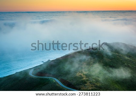 Sunset view of fog over the San Francisco Bay and hills from Hawk Hill, Golden Gate National Recreation Area, in San Francisco, California.