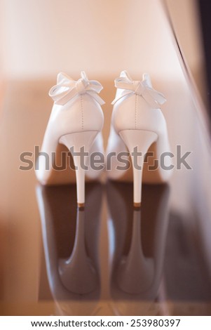 Elegant pair of white bridal shoes on the floor