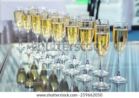 Elegant glasses with champagne standing in a row on table