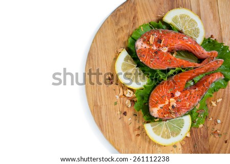 Salmon with spices, seasonings, lemon and green salad isolated
