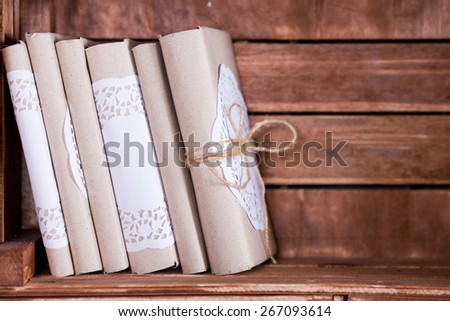 Wood book shelf with old books heap and candle in rustic style