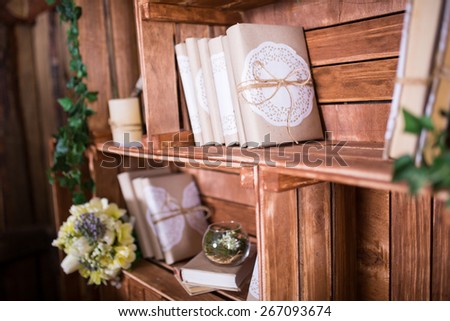 Book heap on wood shelf with flowers in vintage style