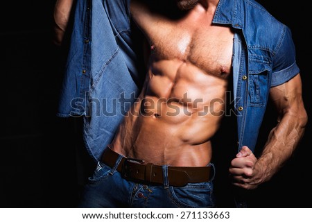 Muscular and sexy body of young sport man in jeans shirt with perfect abs