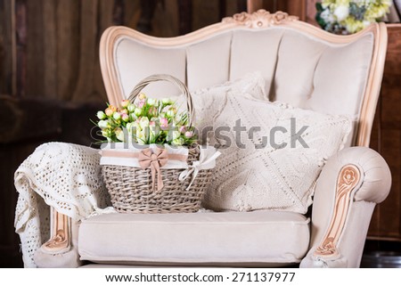 Beautiful tulip flowers in basket on old vintage chair