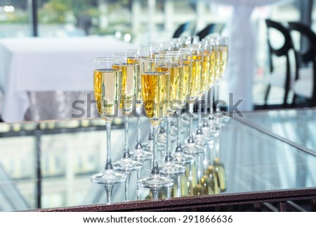 Elegant glasses with champagne standing in a row on table during party