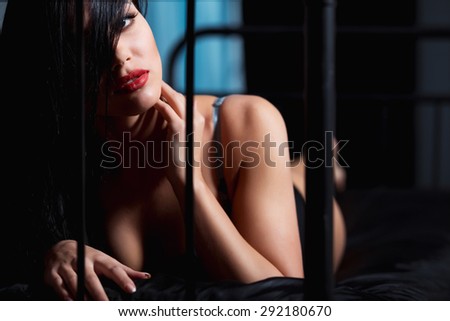 Woman with red lips in lingerie flirting on black bed in a very sexual way
