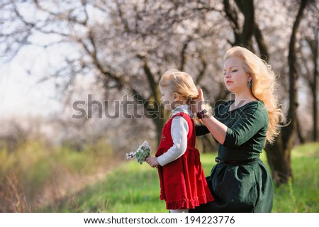 Family walk in the spring garden; mother, and little daughter