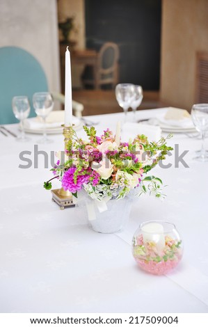 Table set for an event party or wedding reception with candle and flowers