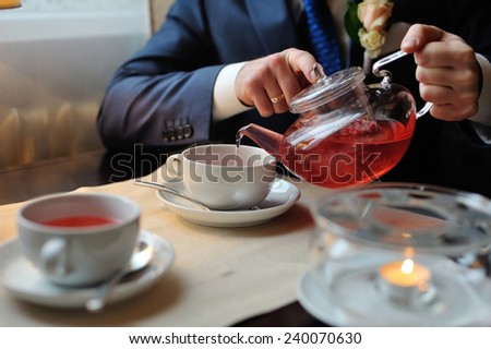 A man pours tea into a cup