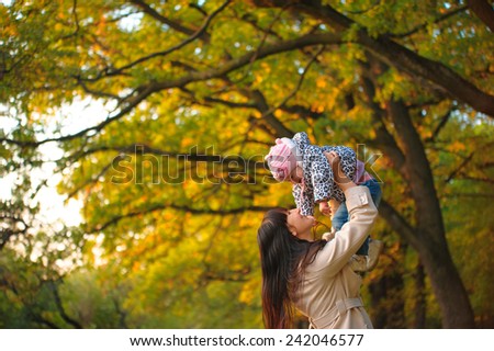 Mom throws baby. lilac bloom, mother and child communication, joy, happiness, emotion, autumn