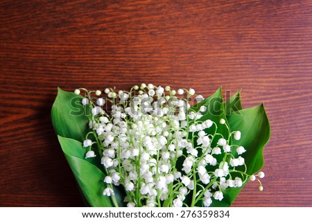 Bouquet of lilies of the valley on the wooden board