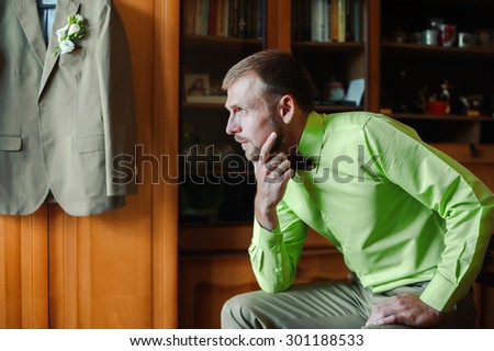 Groom with brown bow tie in green shirt