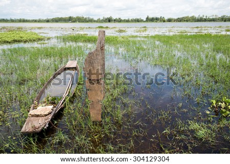 Old wooden canoe fishing boat Asia filled with water after heavy rain storm