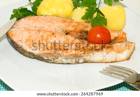 Grilled Salmon Steak with cherry tomato potatoes and parsley. Italian cuisine