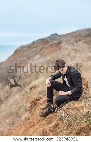 a man sits and thinks frantically over the precipice