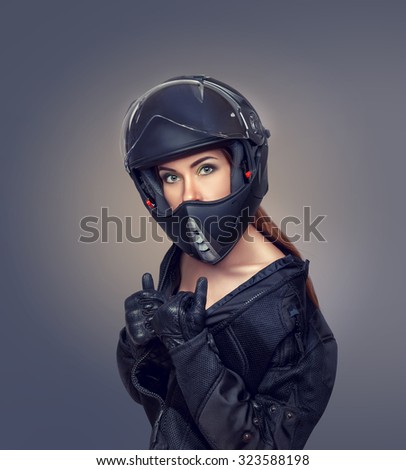 Girl motorcyclist in a black jacket, helmet and gloves
