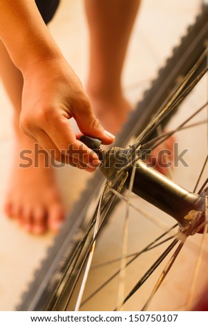young boy fixing old mountain bike wheel. Focus on the fingers
