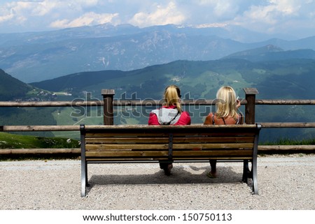 resting and smoking. two girls with hidden face, sitting on a bench and smoking. Kindly notice that faces cannot be recognized