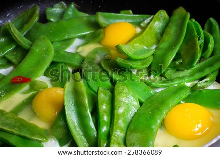 Fried snow peas with egg, chilly and salt