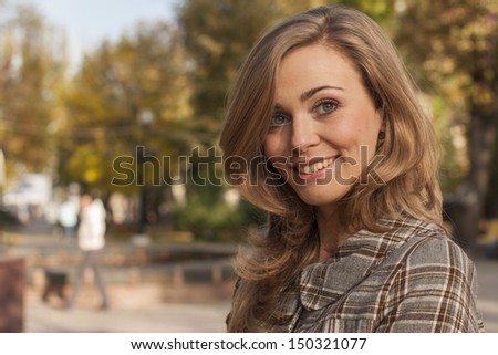 beautiful young woman outside in autumn city park dressed in casual