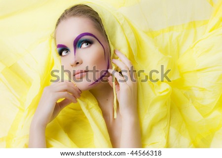 Beauty girl with a bright colored makeup and drawing face