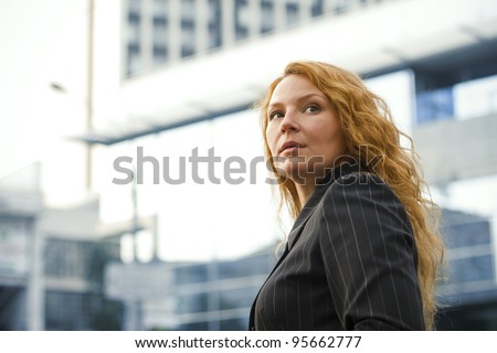 red-haired business woman leader outside the office building