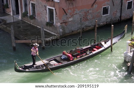 VENICE, ITALY - SEPTEMBER 08, 2009: Gondolier in the process of mooring his Gondolar close to the Accademia bridge.