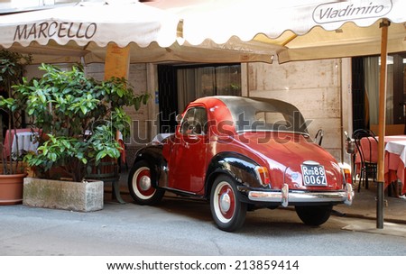 ROME, ITALY - APRIL 11, 2010: Classic car parked outside restaurant in Rome.
