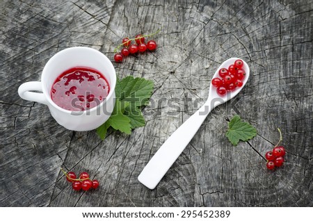 Red currants jam on wood background