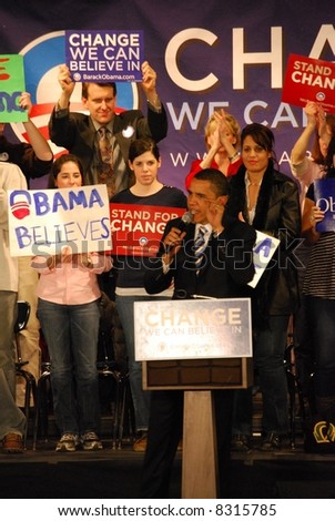 Senator Barack Obama campaigning for president, lifting hand and supporters rallying