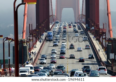 Zoom of heavy traffic on Golden Gate Bridge, connecting San Francisco to Marin County, warm air rising from road and cars in the front