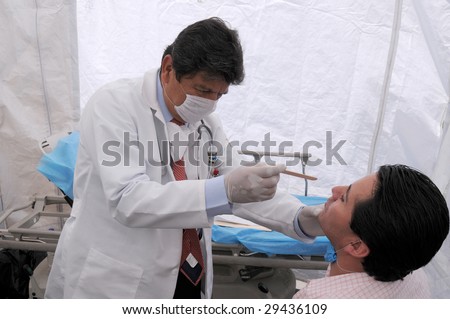MEXICO CITY - APRIL 29: A doctor examines a flu patient for signs of Swine Flu at a makeshift clinic on April 29, 2009 in Mexico City.