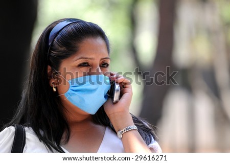 MEXICO CITY - APRIL 30:A woman talks on her cellphone while protecting herself against influenza with a face mask on April 30, 2009 in Mexico City.