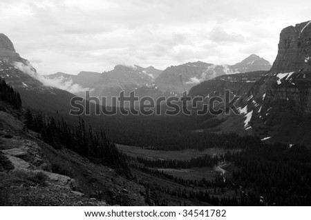 A black and white photo of a U-shaped valley at the Logan Pass on the Going-to-the-Sun Road in the Glacier National Park in Montana, northwestern USA, shot in early July.