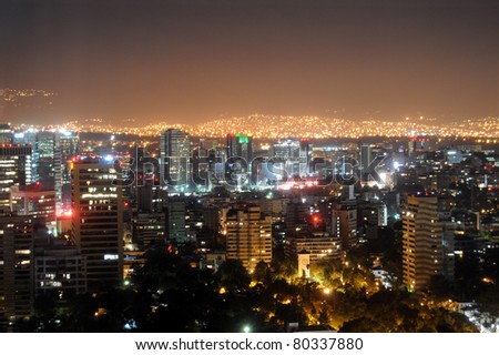 Downtown Mexico City skyline at night, with brightly lit suburban barrios in the background