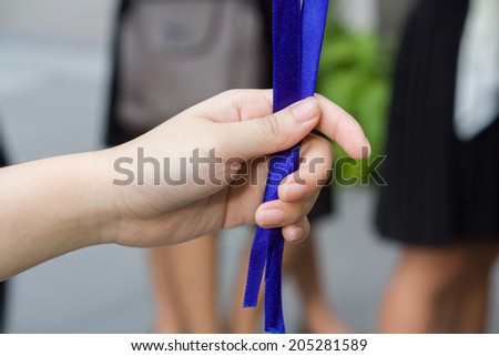 a hand is pulling some blue ribbons