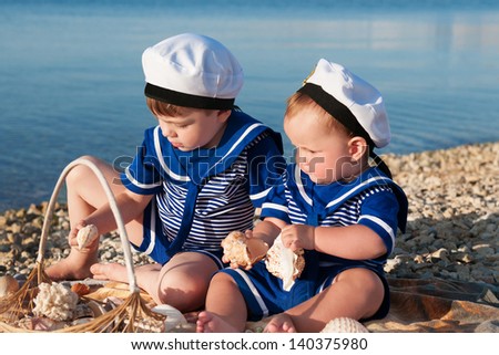 happy small children in a suit of the seaman smiling and having fun on the sea. adorable cute kids playing and resting on nature. trendy  funny children on nature enjoying the sun in park and posing